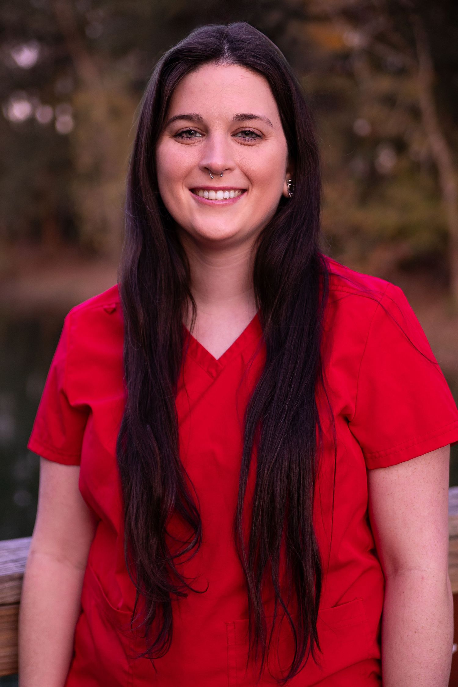 Portrait series of graduate in bright red outfit against outdoor backdrop.
