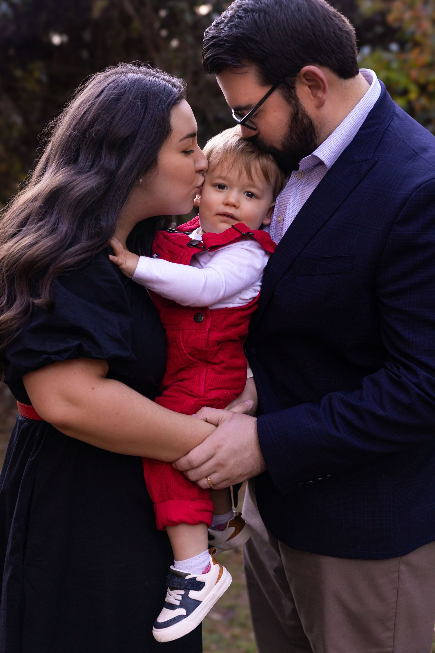 A loving family moment captured in a series of tender embraces outdoors.