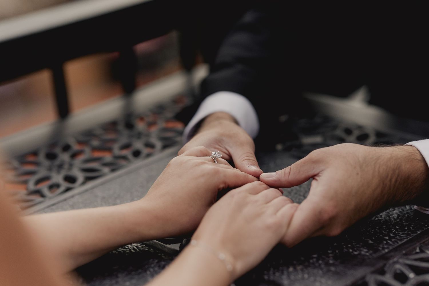 Close-up of groom placing wedding ring on brides finger