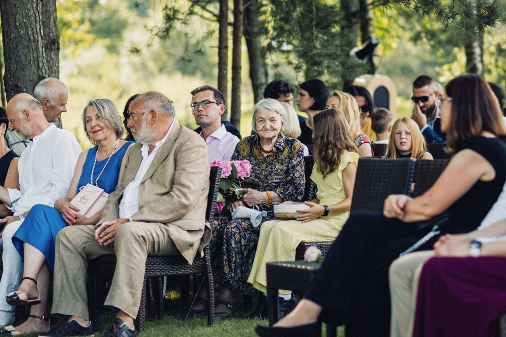 Vestuvių svečiai lauko ceremonijoje Vilniuje – reportažinė vestuvių fotografija su natūraliomis emocijomis