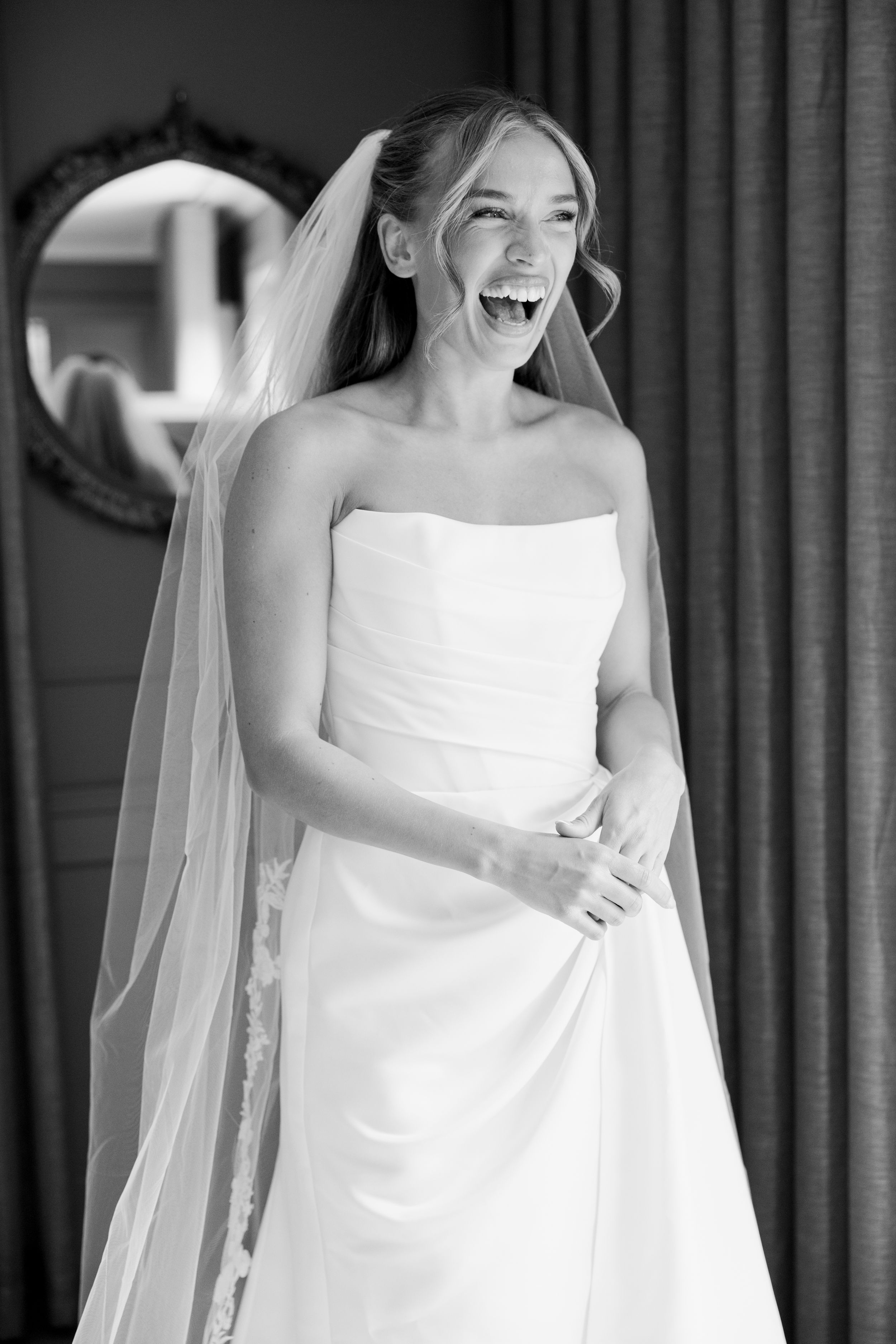 A candid black and white photo series showing a joyful bride in a strapless wedding dress laughing naturally.