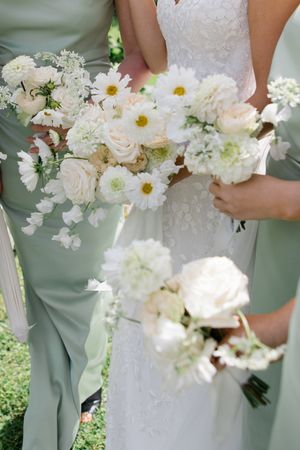 Elegant white wedding bouquets featuring daisies, roses and delicate greenery against sage bridesmaid dresses.