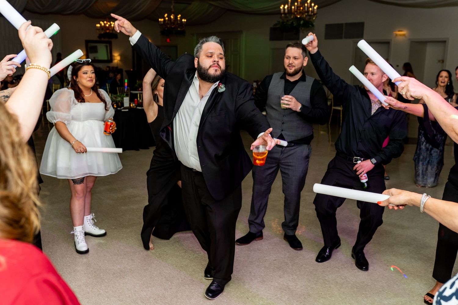 Lively dance party at a wedding reception with people dancing and celebrating on the dance floor.