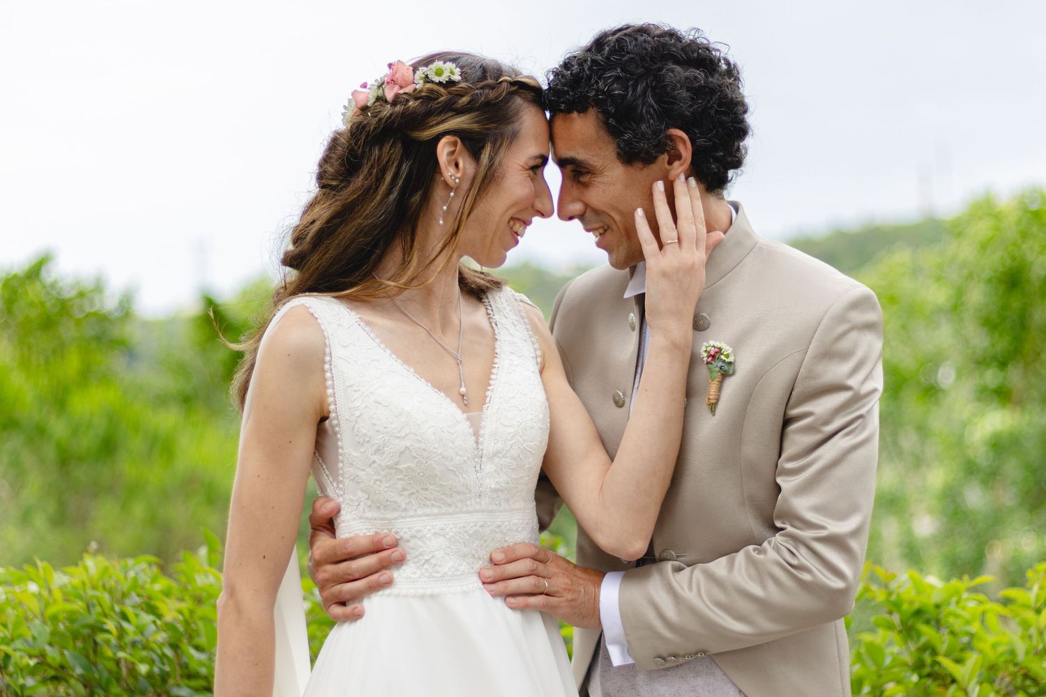Romantic wedding couple embracing in a natural outdoor setting.
