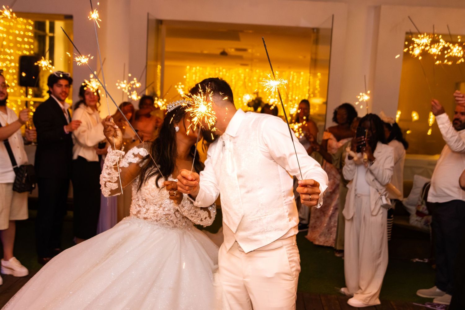 Festive wedding reception scene with warm lighting and dancing guests.