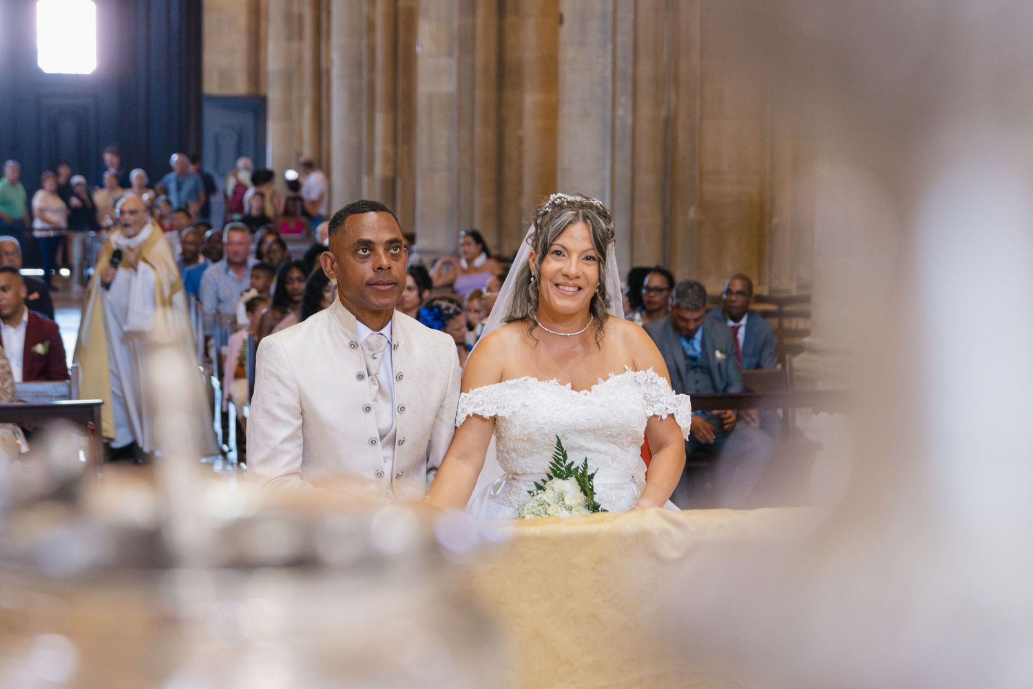 Elegant church wedding ceremony with couple in white attire exchanging vows at the altar.