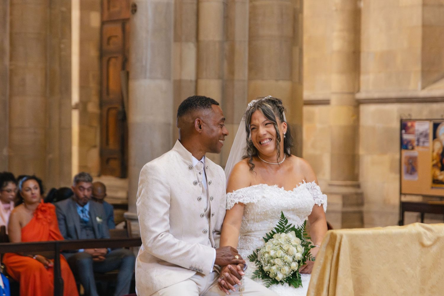 Romantic church wedding ceremony with stone columns and natural lighting.