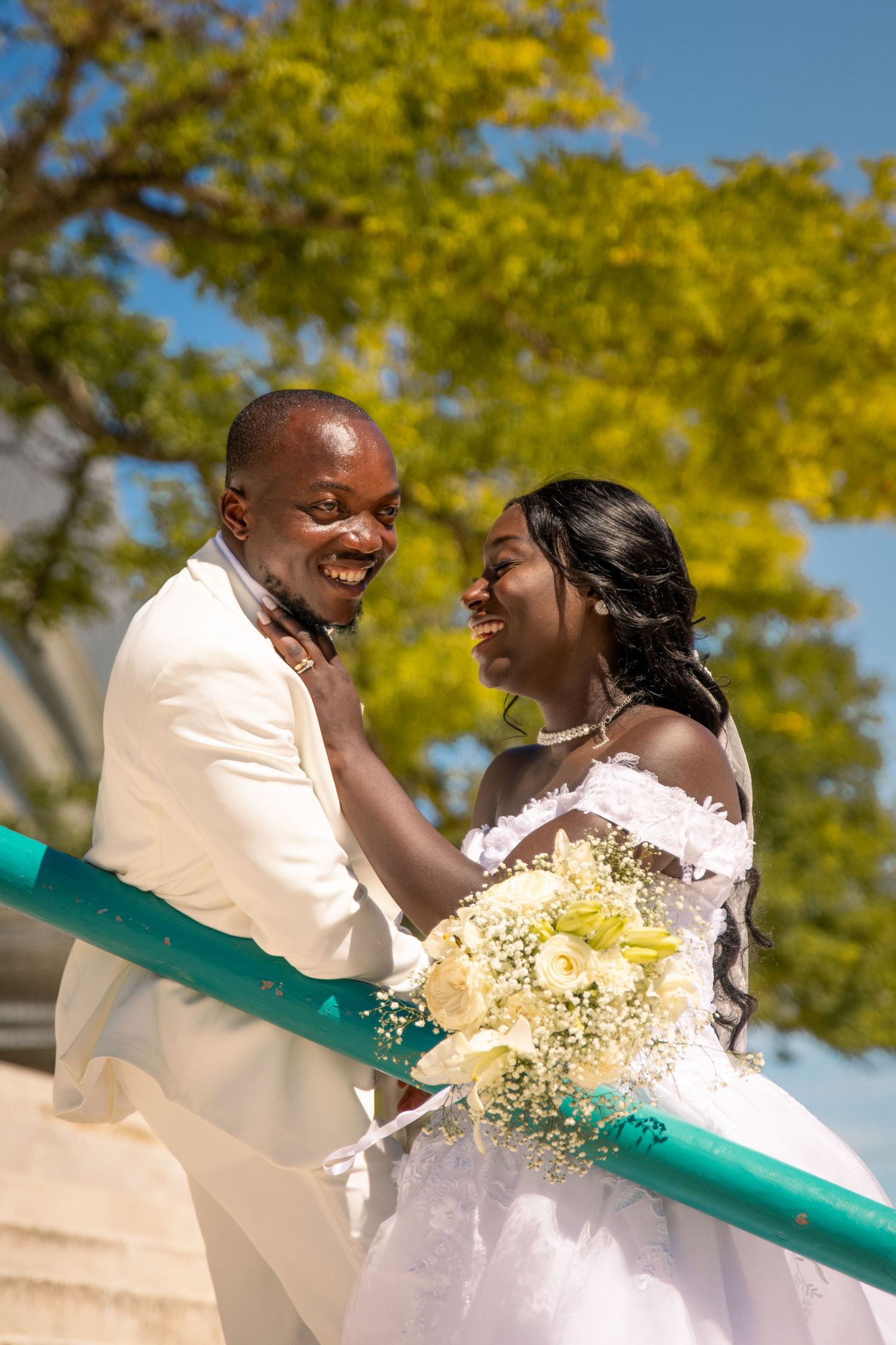 Happy couple laughs together during their outdoor wedding photoshoot.