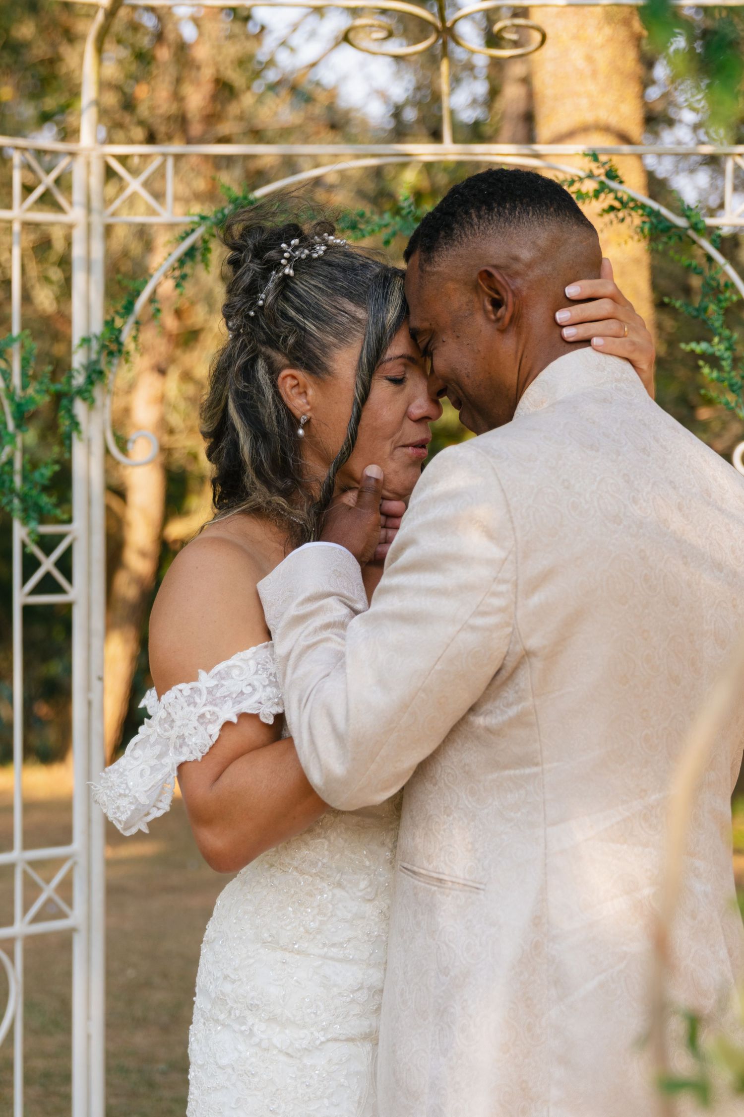 Intimate outdoor wedding portraits showing tender moments between newlyweds.
