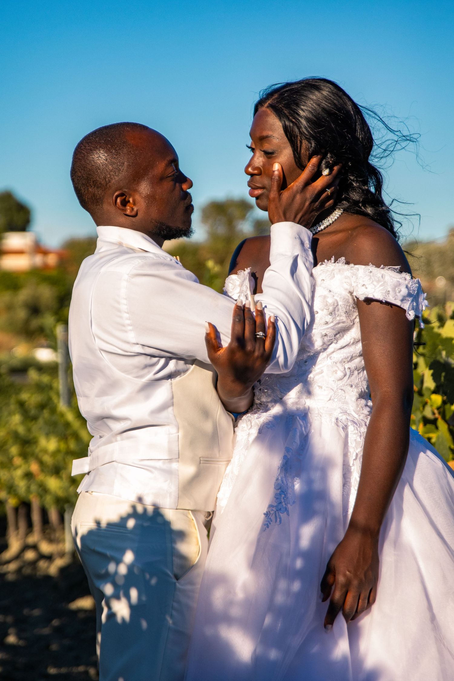 Wedding couple dances playfully in bright sunlight during their outdoor celebration.