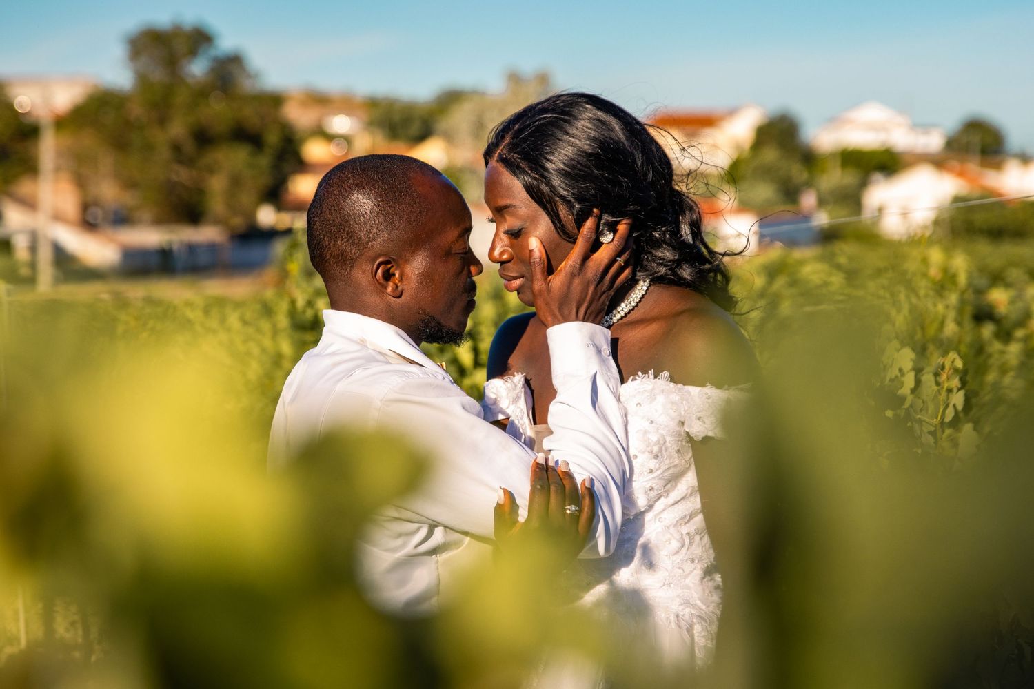 Couple shares a romantic dance moment against a sunlit natural backdrop.