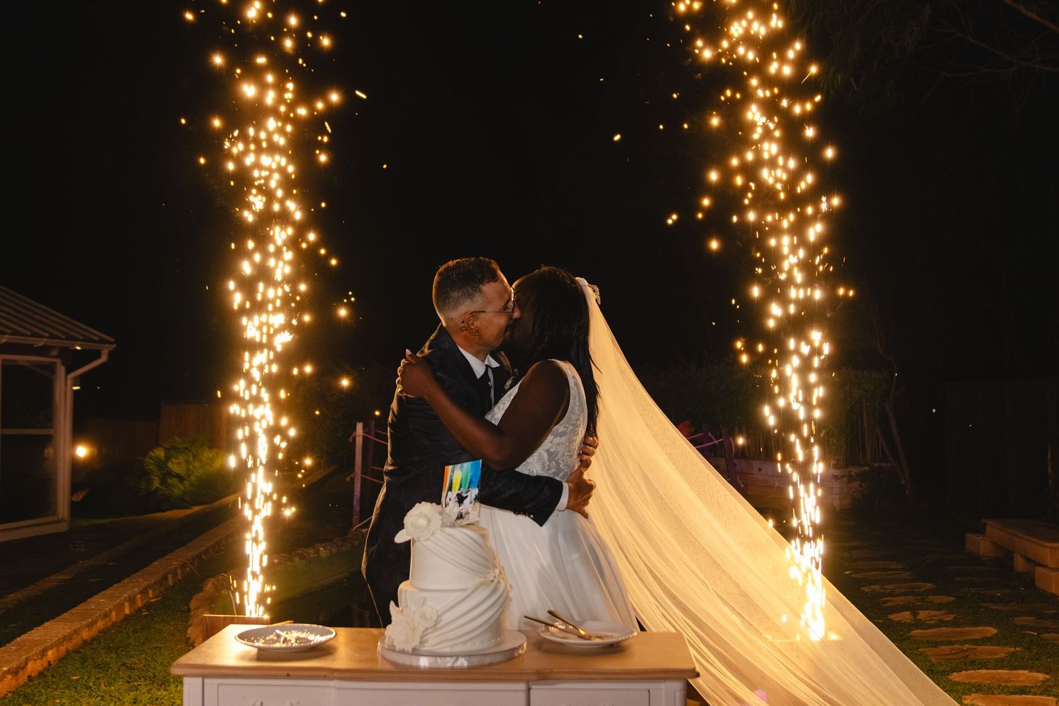 Wedding sparklers create magical light trails during evening celebration.