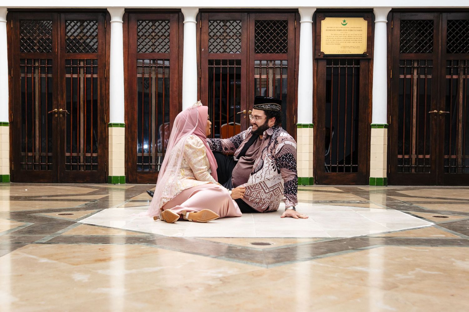People sitting and studying in traditional Islamic architecture setting.