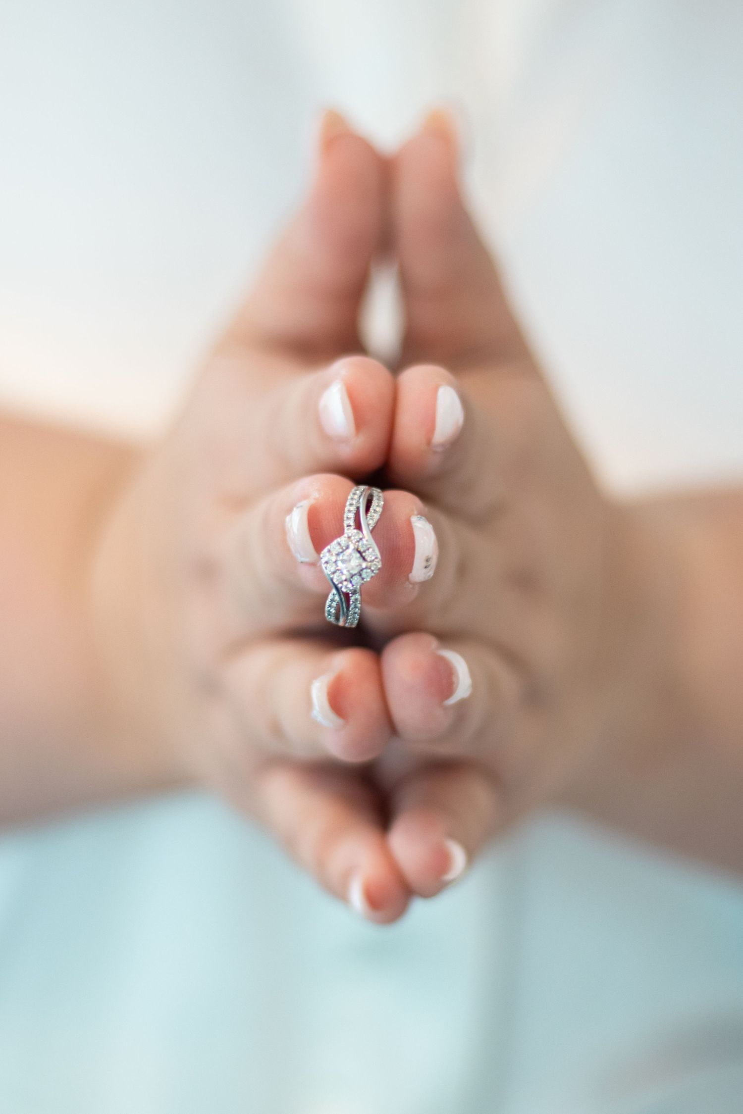 Close-up shots of hands displaying an elegant diamond engagement ring.