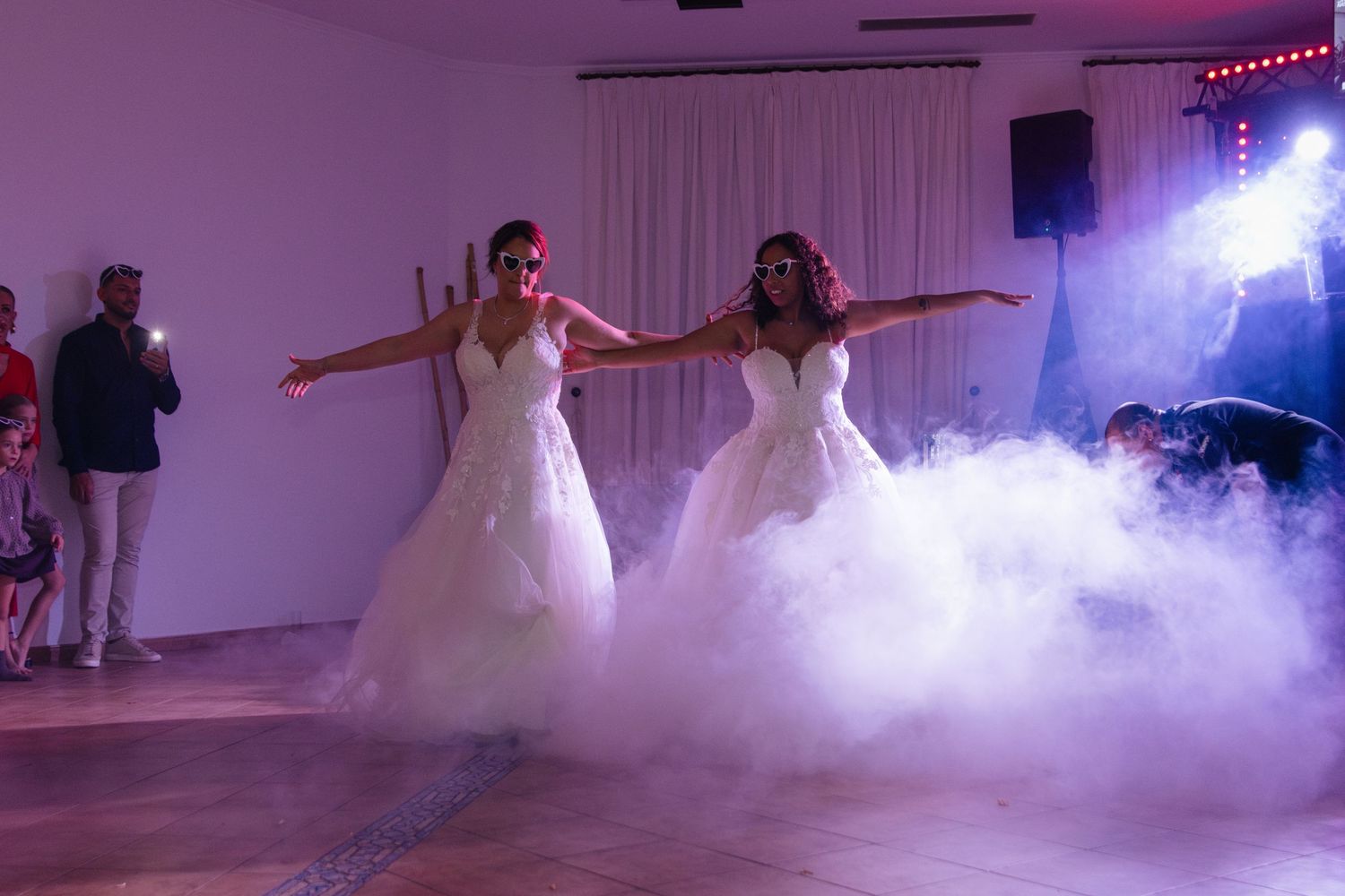 Wedding celebration with dramatic fog effects and purple lighting on a dance floor.
