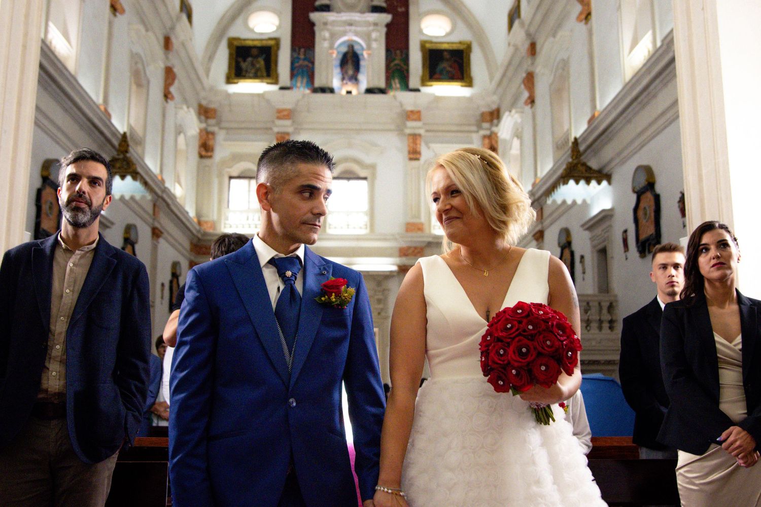 Wedding party celebration inside ornate classical building with arched ceilings.