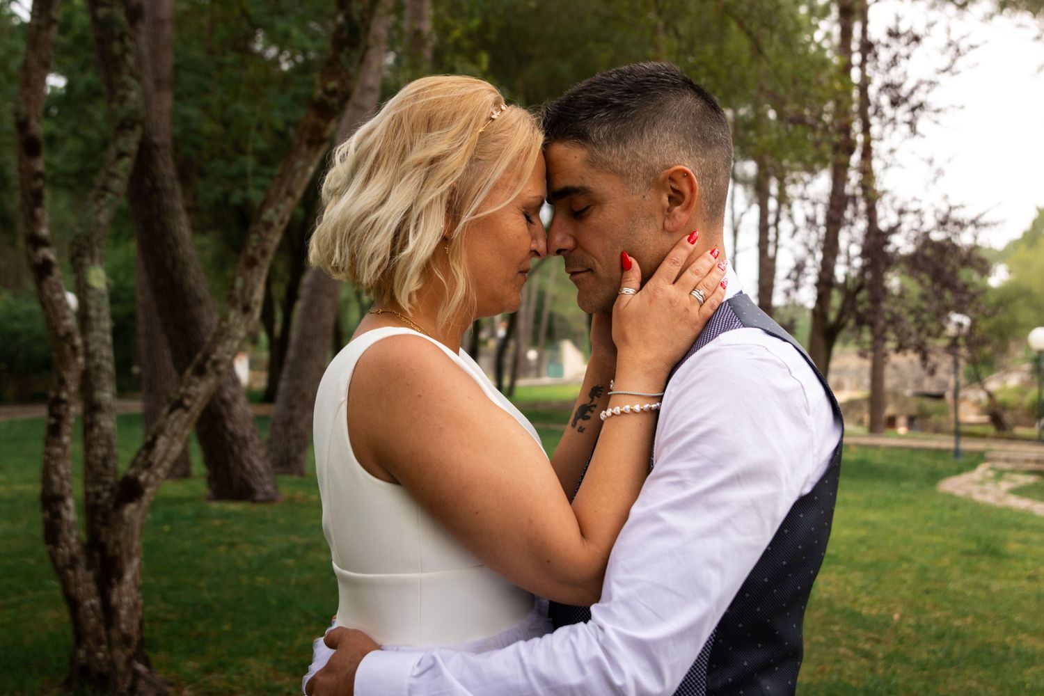 Intimate wedding portraits taken among trees in natural outdoor setting.