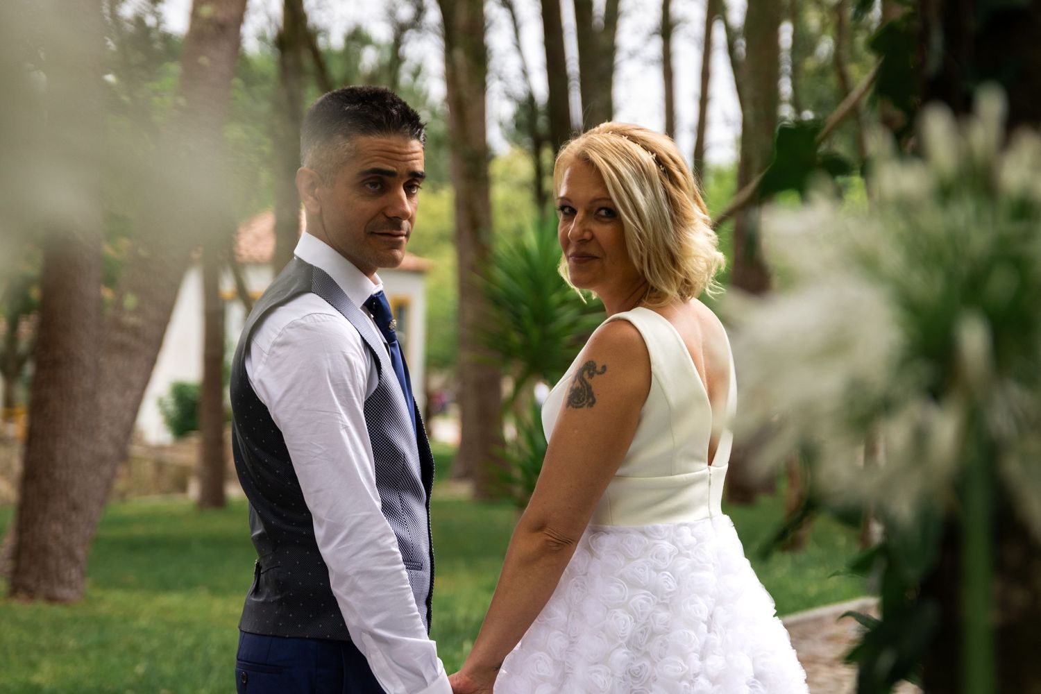 Wedding couple shares tender moments in garden setting during photo session.