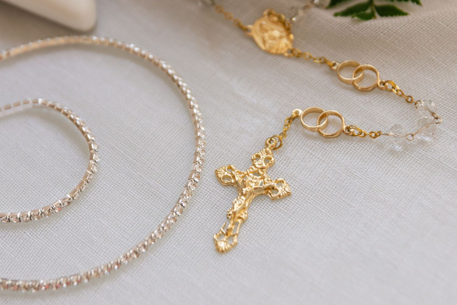 Delicate gold and pearl wedding jewelry displayed on white surface.