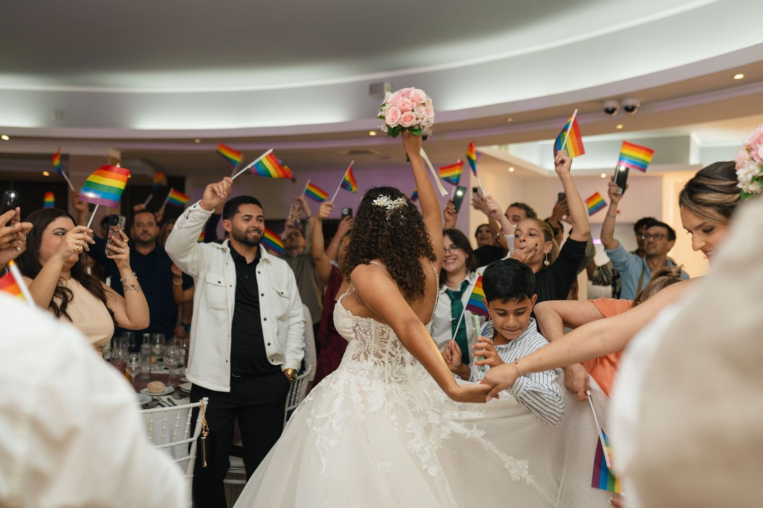 Wedding reception guests dancing and celebrating with colorful light-up props.