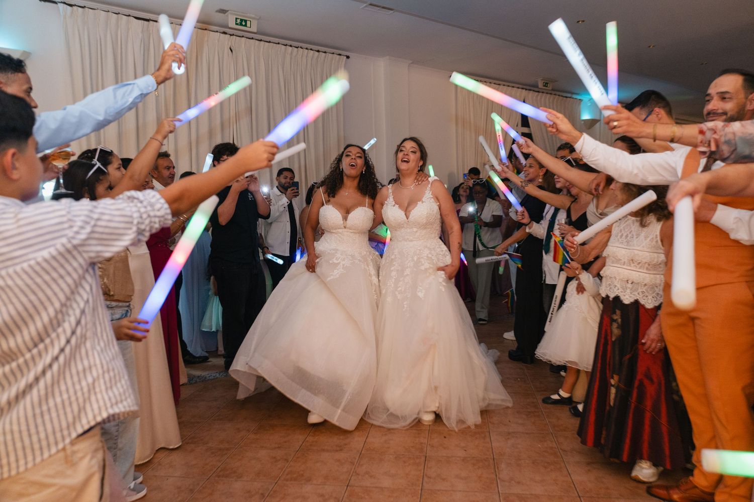 Wedding celebration with guests holding illuminated lightsabers creating a magical tunnel effect.