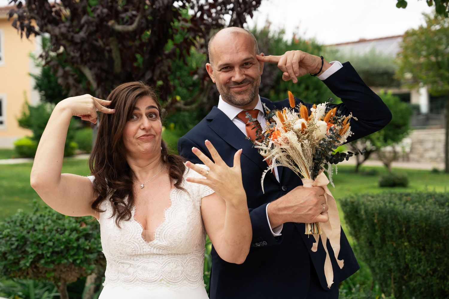 Wedding couple shares playful dance moves during their outdoor celebration.