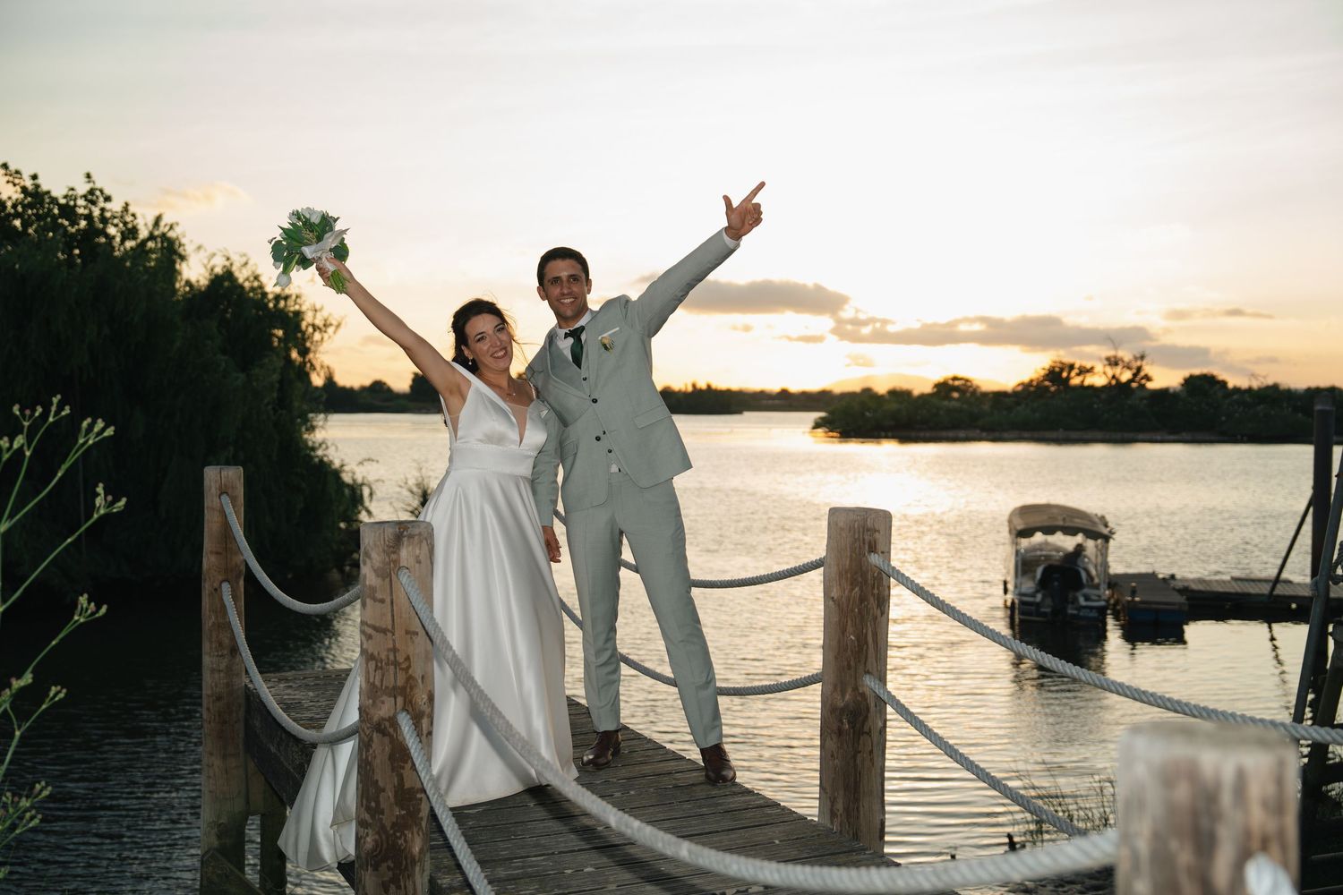 A sunset wedding photoshoot on a wooden dock by the water.