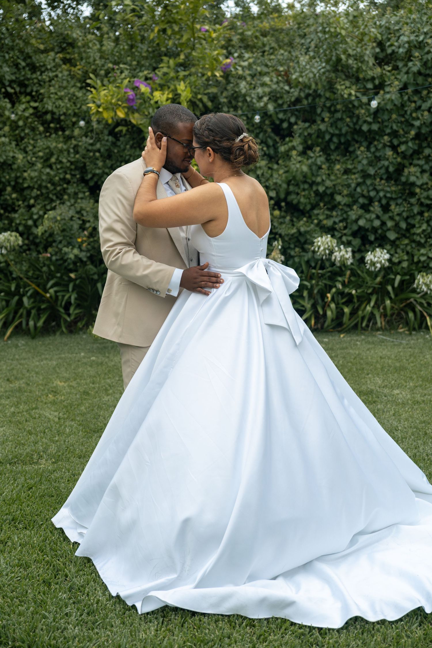 A flowing white wedding dress creates elegant silhouettes against a garden backdrop.