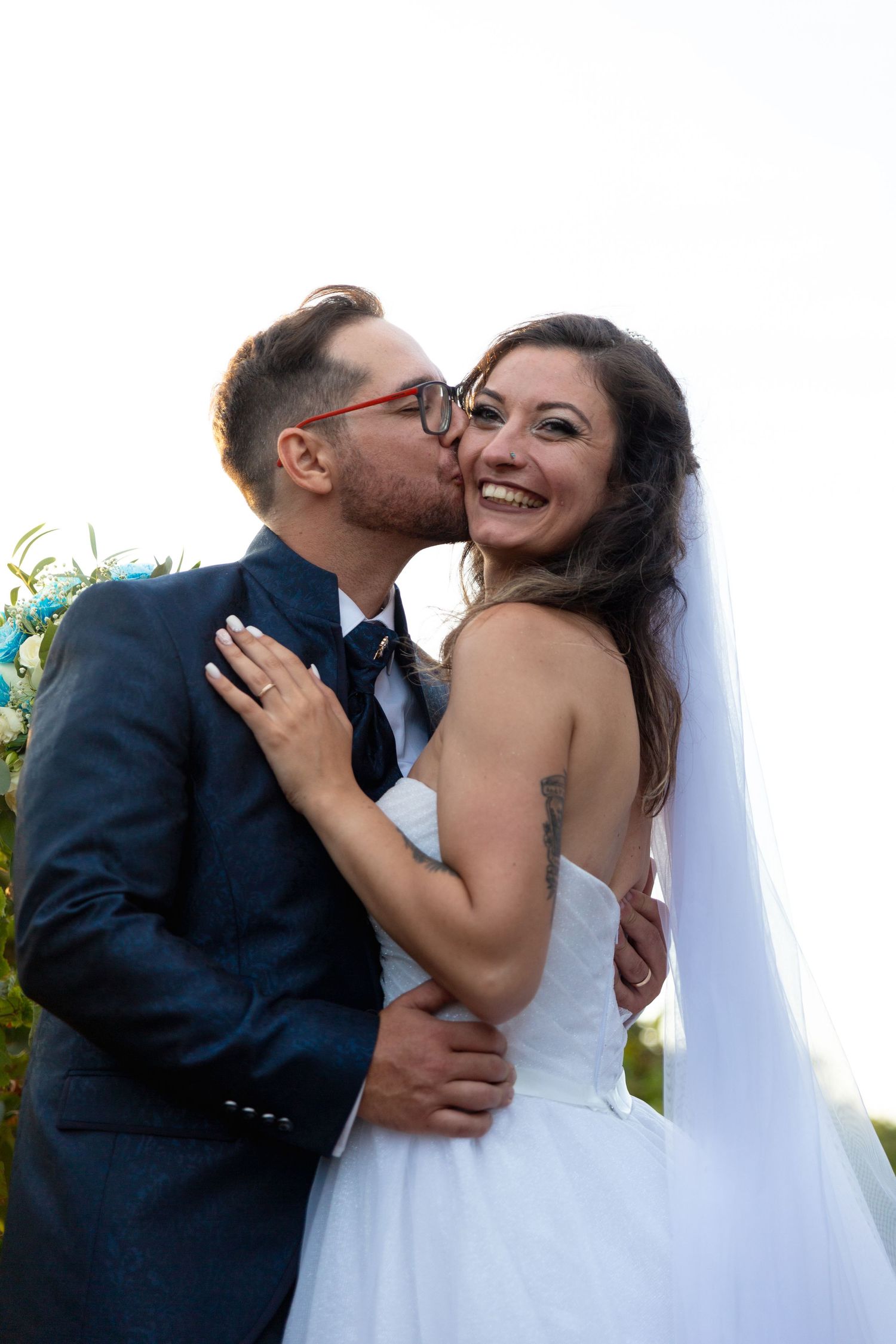 Candid wedding photos capture tender moments between newlyweds embracing outdoors.