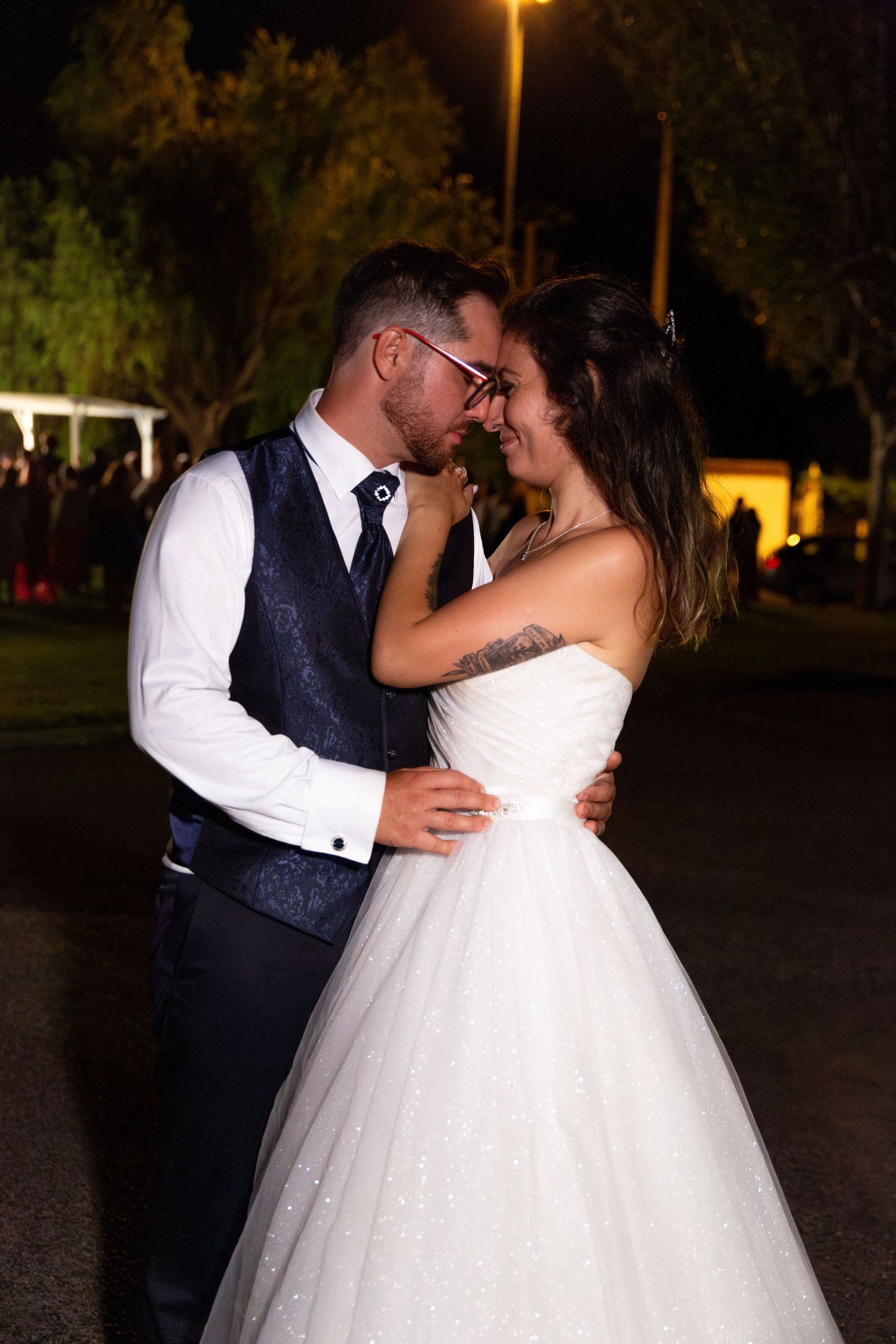 Nighttime wedding photos show dancing and embracing under outdoor lighting.