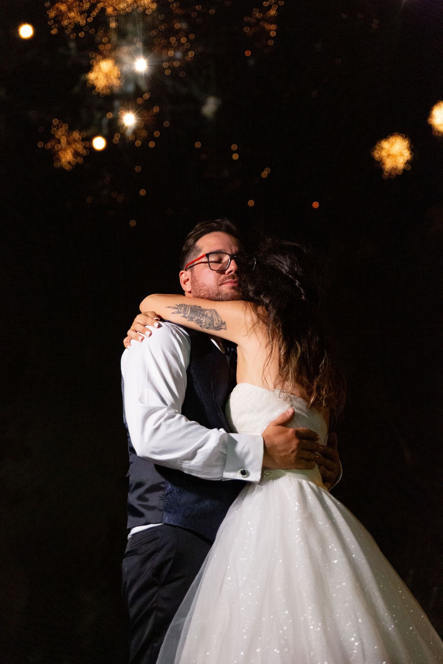 Romantic nighttime wedding photos with sparklers and ambient lighting creating a magical atmosphere.