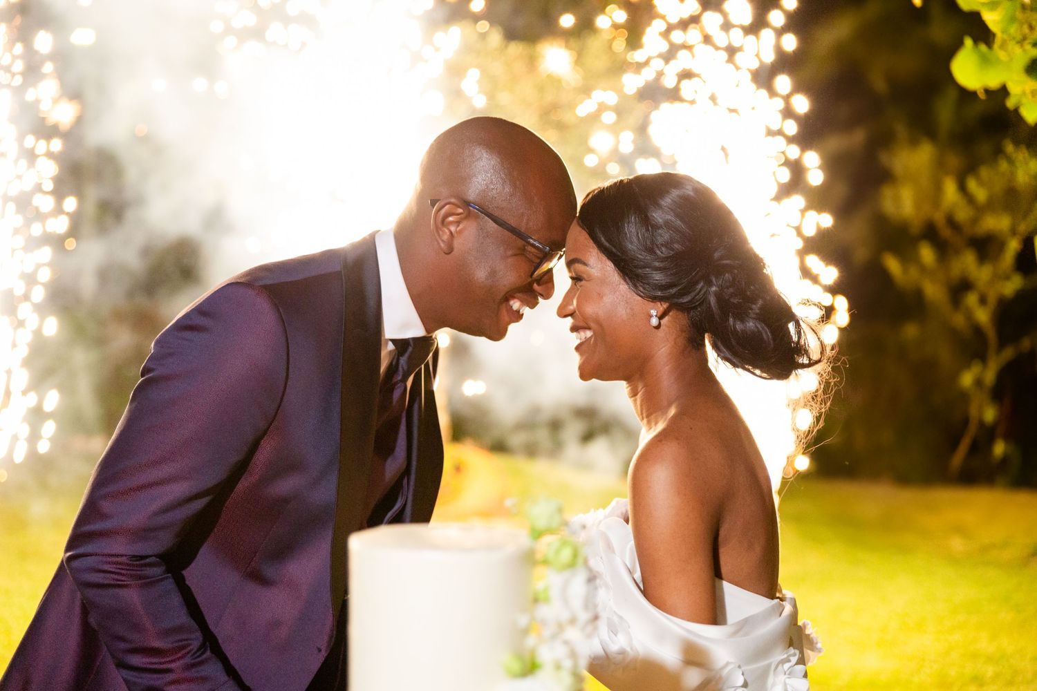 Romantic wedding portrait of a couple against a golden sunset backdrop.