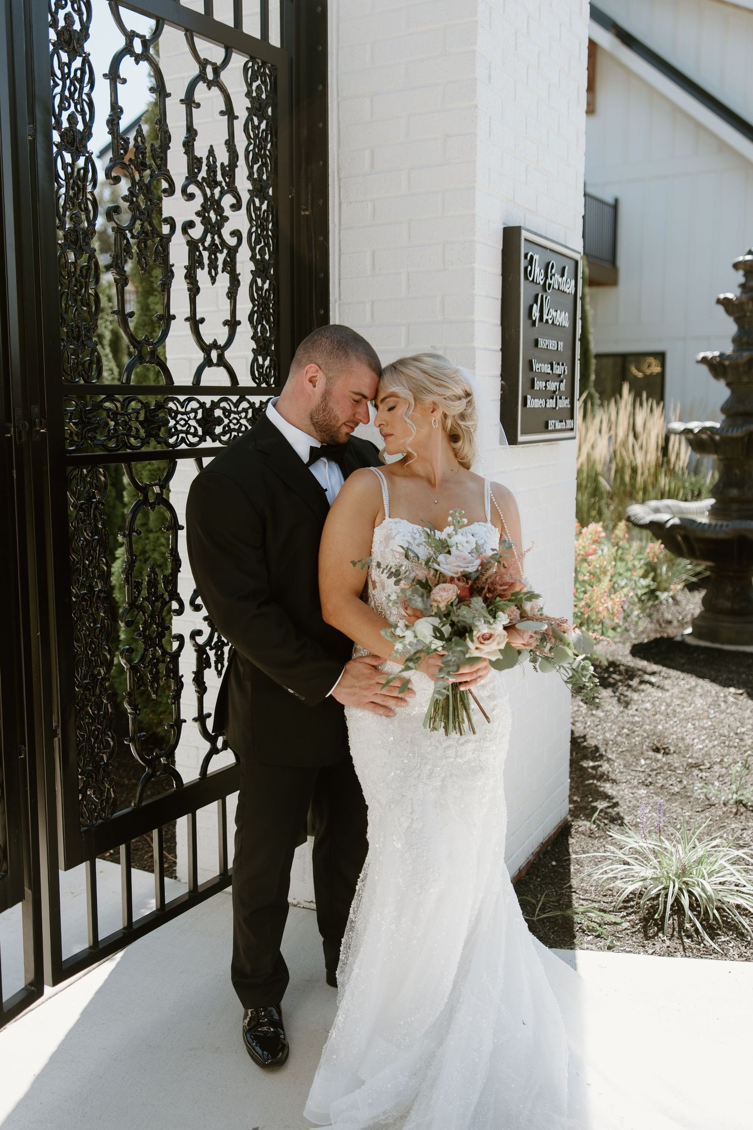 Bride and groom in elegant attire during first look photos against minimalist backdrop.