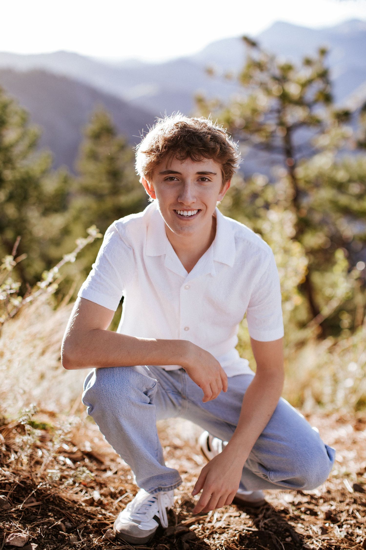 Sara Prue Photography captures the spirit of youth in this stunning high school senior portrait with a mountain backdrop.