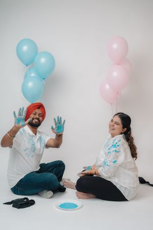 A gender reveal photo sequence with blue and pink balloons showing a couple's playful reactions to discovering their baby's gender.