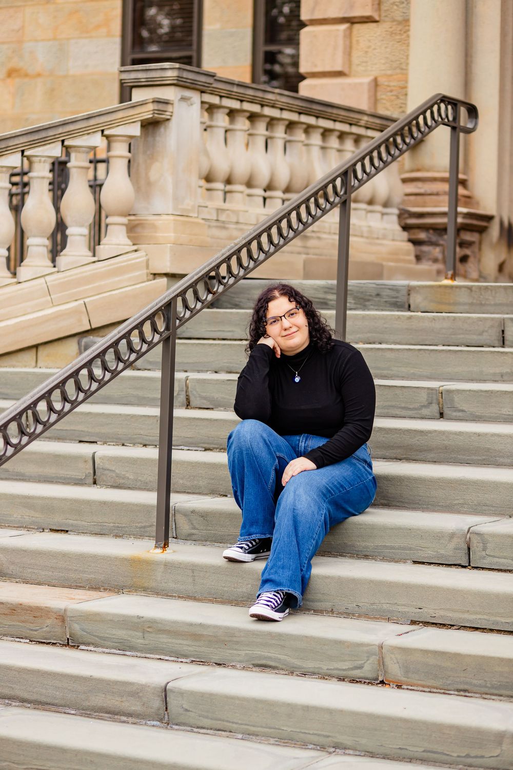 Senior girl sitting on concrete steps, outdoor photo session graduation