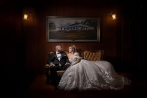 Romantic wedding portrait in vintage setting with soft lighting and classic wall decor.