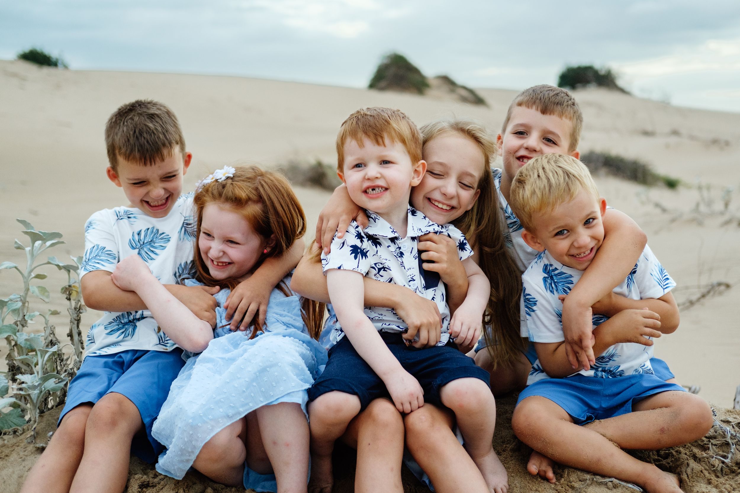 Group of children sharing a joyful hug on Mtunzini beach