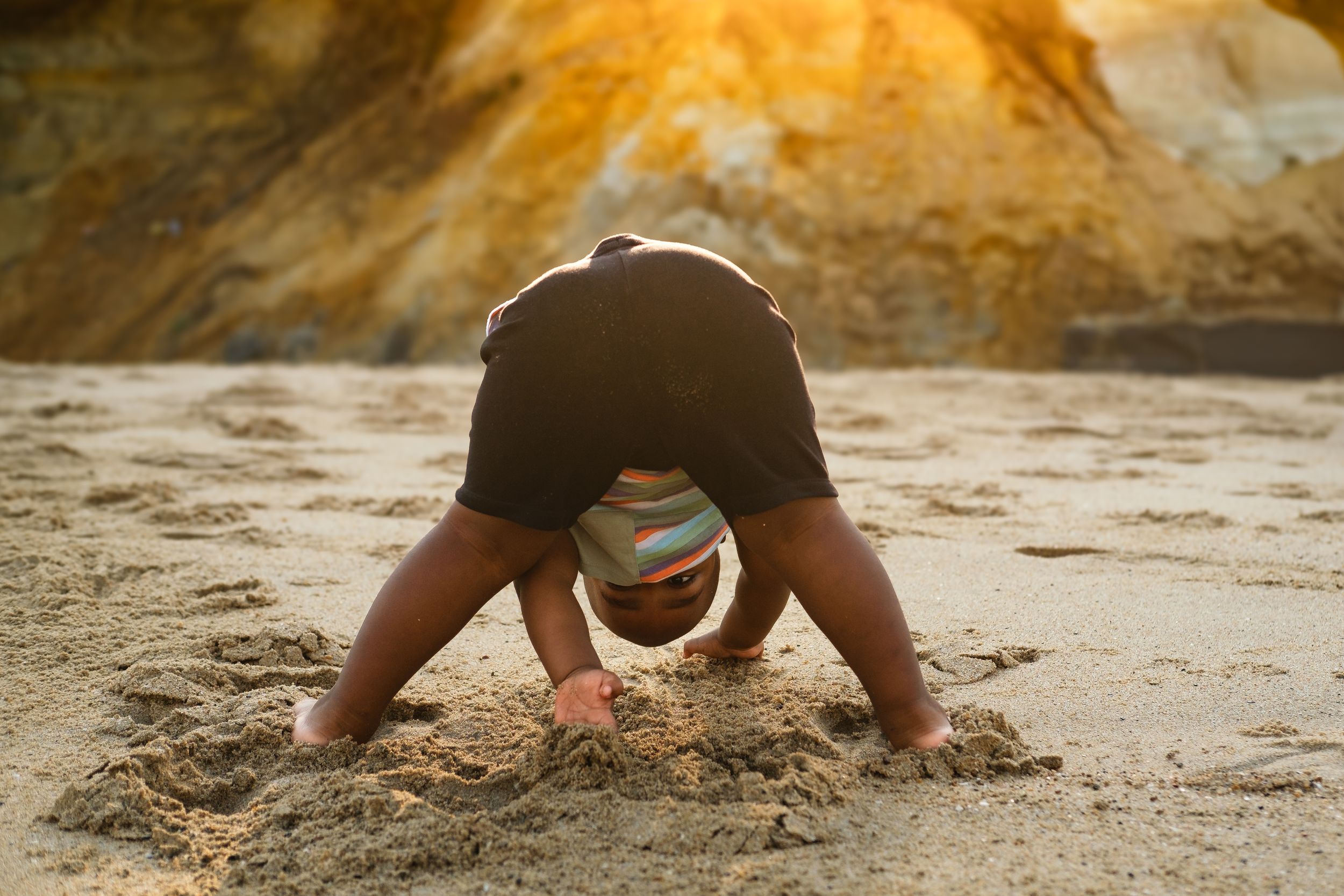 Little boy playing with sand on the beach