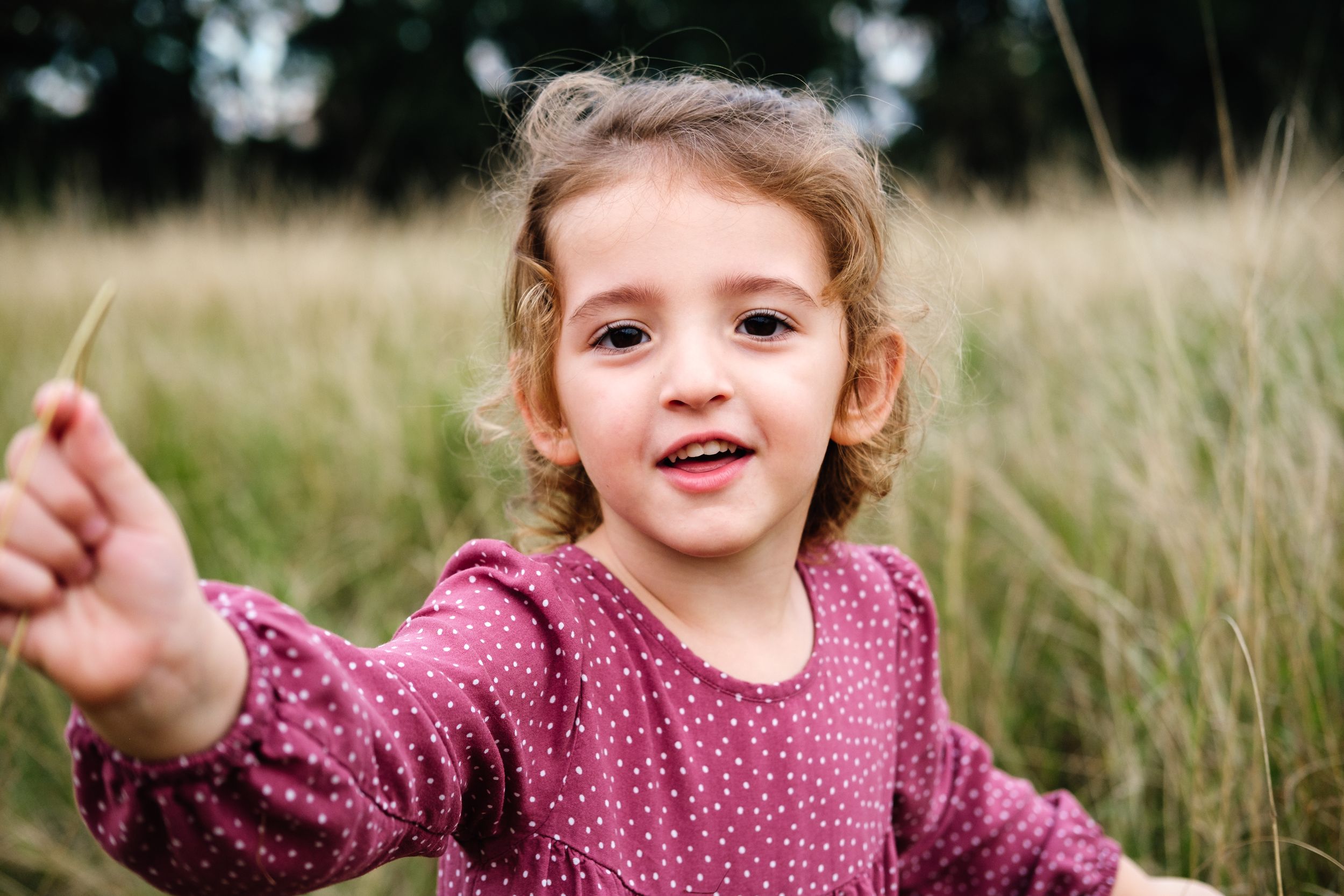 Little girl laughing freely in a grassy field