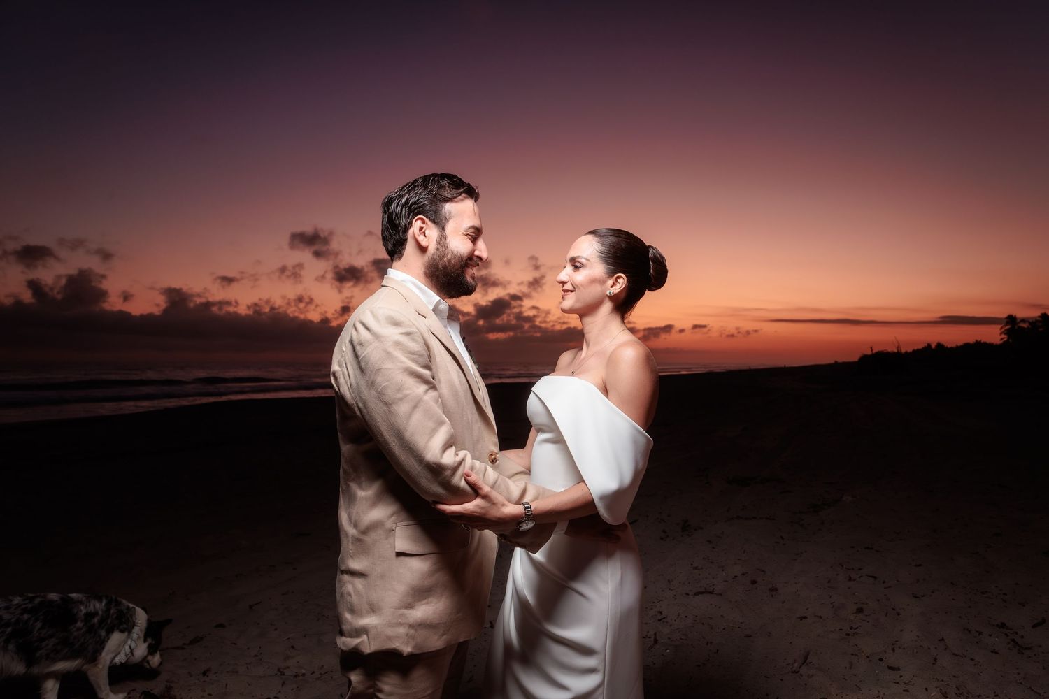 Romantic sunset silhouettes of a couple dancing together on a beach at dusk.
