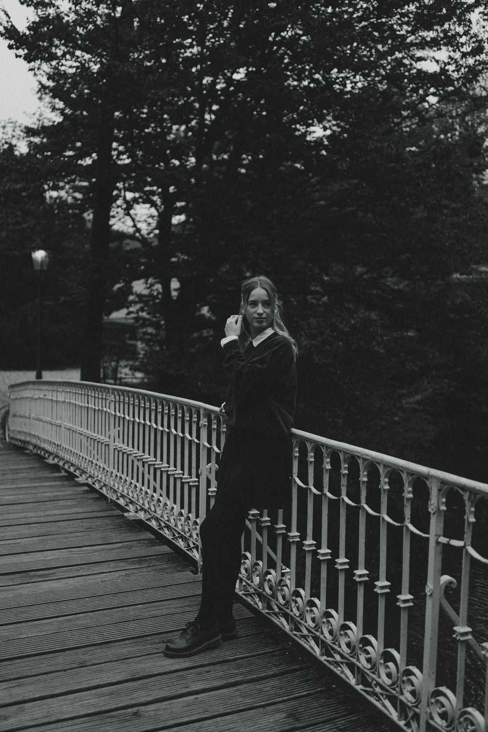 Frau lehnt an Geländer von Parkbrücke und fässt sich dabei durch die Haare - Vintage Fotoshooting im Großen Garten Dresden