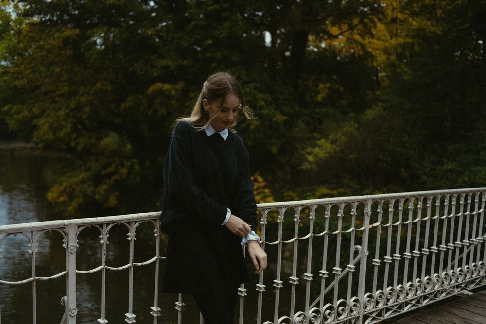 Nostalgisches Fotoshooting am Carolasee - Frau richtet sich Ärmel am Pullover auf Brücke im Großen Garten in Dresden