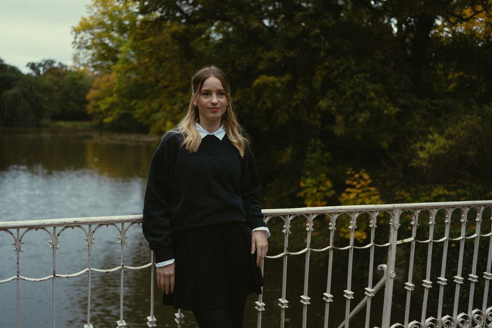 Vintage Fotoshooting - Stimmungsvolles Parkportrait einer jungen Frau auf einer Brücke an das Geländer lehnend, im HIntergrund der Carolasee