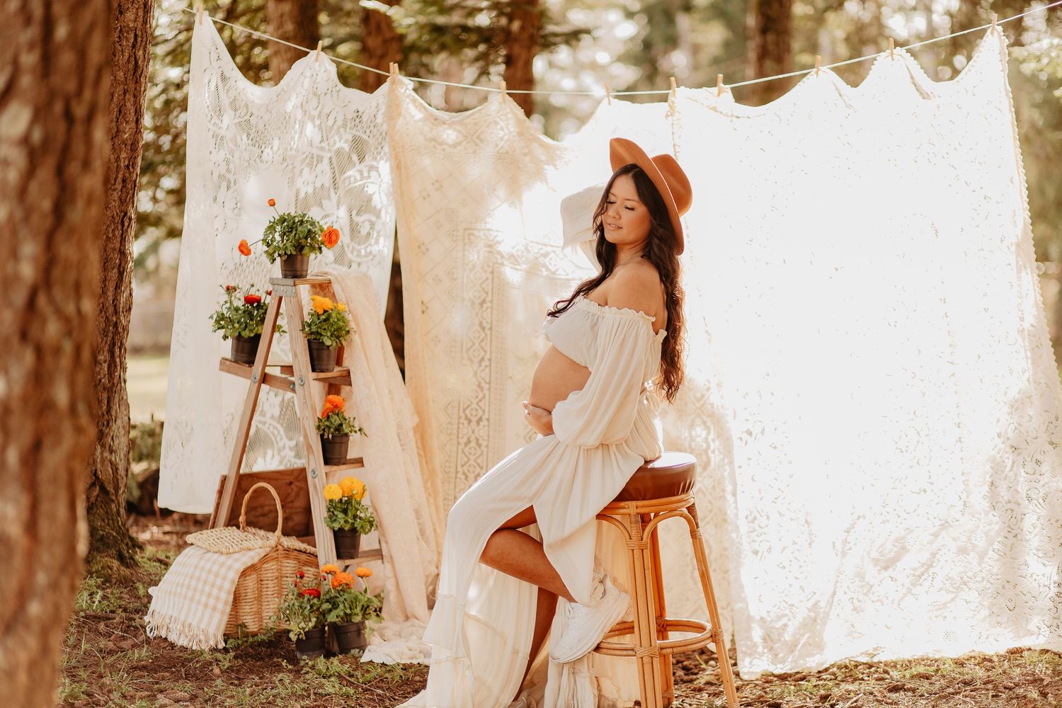 Wedding party poses under trees with flowing white fabric decorations.