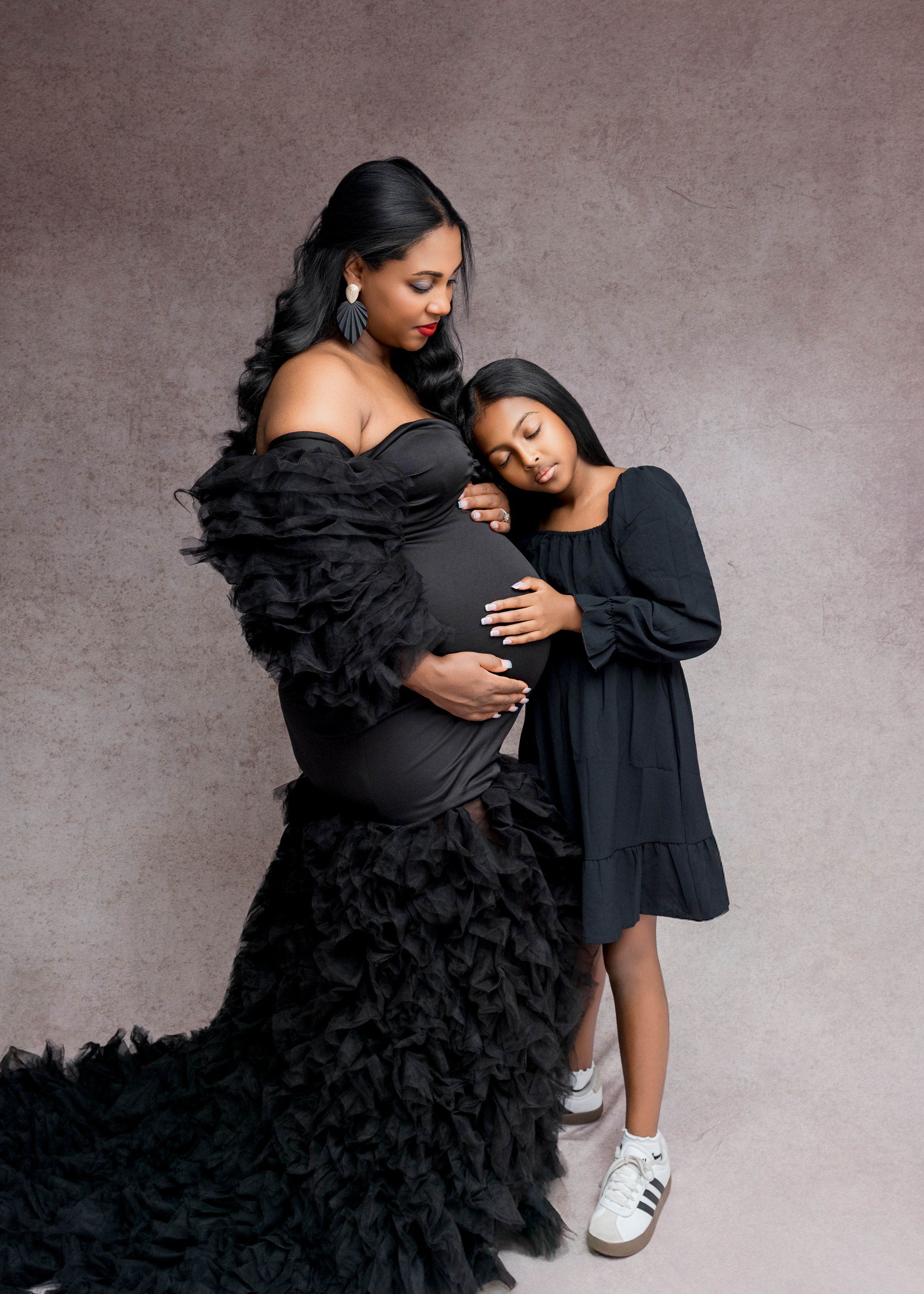 A series of artistic black and white fashion photos showing a dramatic ruffled black dress against a gray backdrop.
