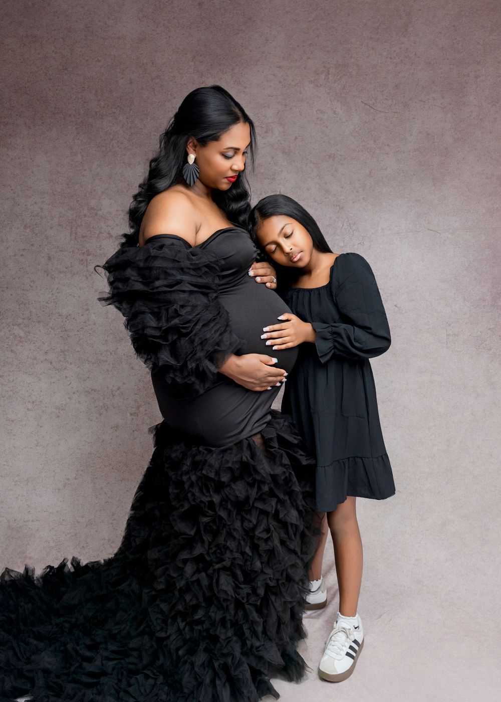 A series of artistic black and white fashion photos showing a dramatic ruffled black dress against a gray backdrop.