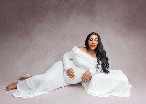 A person in a flowing white dress poses gracefully on the floor in a series of artistic portrait shots.