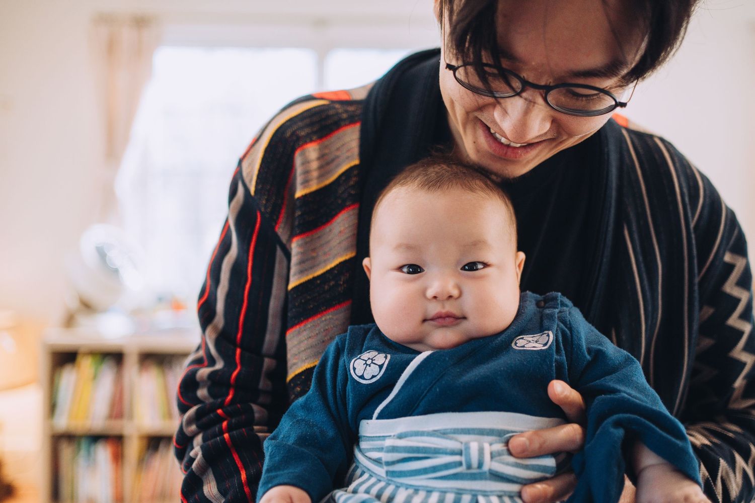A dad holds a baby dressed traditionally for the baby's 100th Day Celebration. Shannon Konek, Pittsburgh Photographer