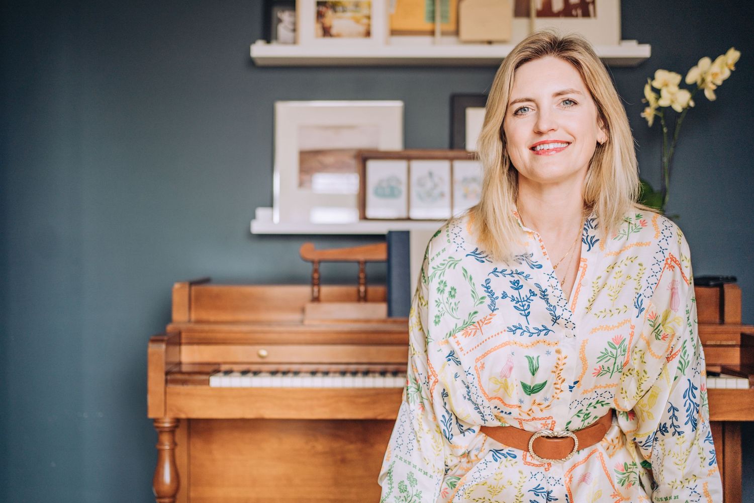 A woman wearing a colorful dress, sitting in front of a piano. Shannon Konek, Pittsburgh Photographer
